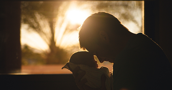 Father holding baby in sunlight
